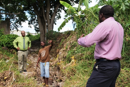 Project Manager for Contractors Surrey Paving &Aggregate Co. Caribbean Ltd. Mr. Desmond Lewis (right) with Lower Stoney Grove resident Mr. Dale Claxton (middle) and Premier of Nevis Hon. Joseph Parry during a walkthrough of the Bath Ghaut to see firsthand the damage caused by flood waters